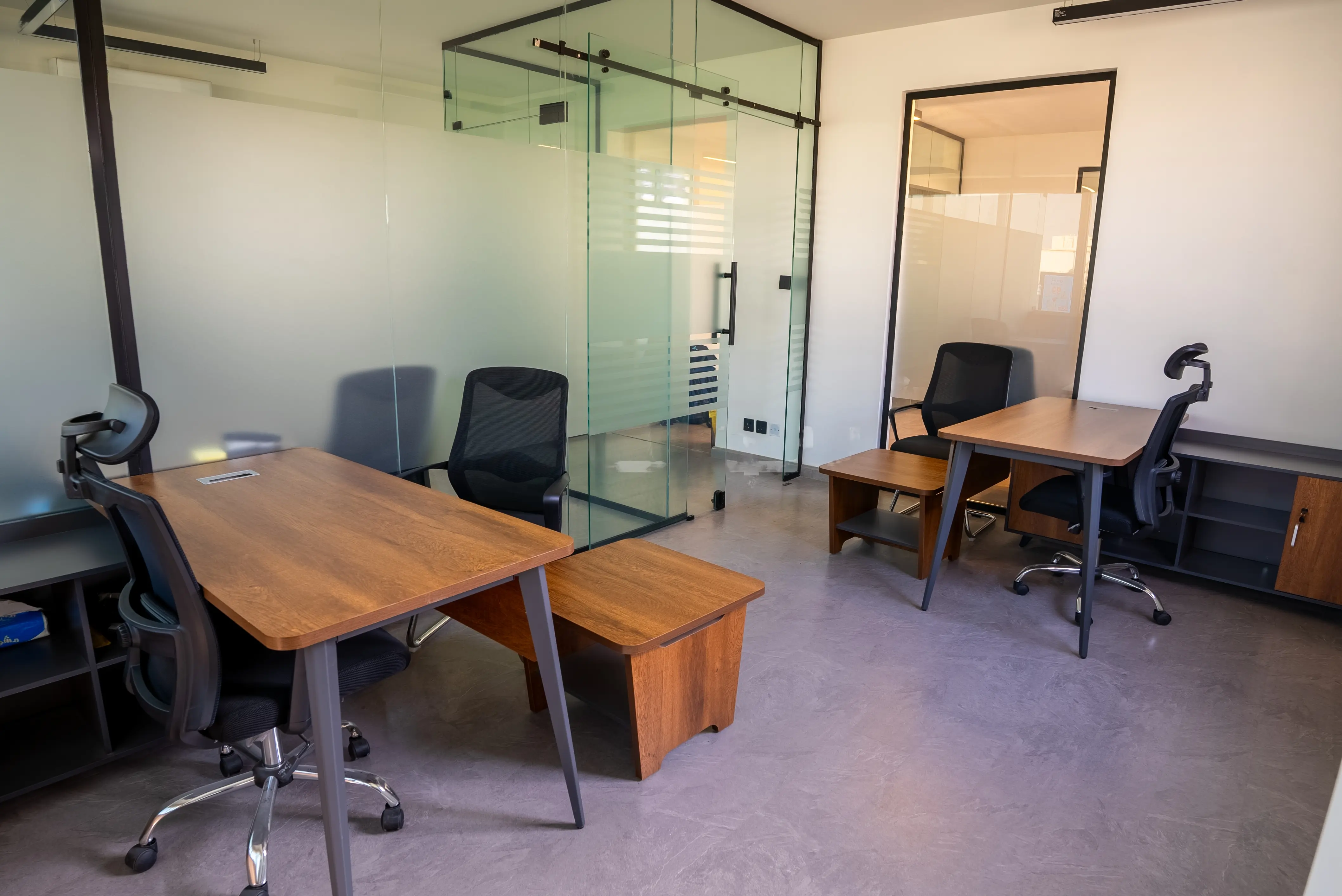 Interior of modern office with glass walls and wooden desks